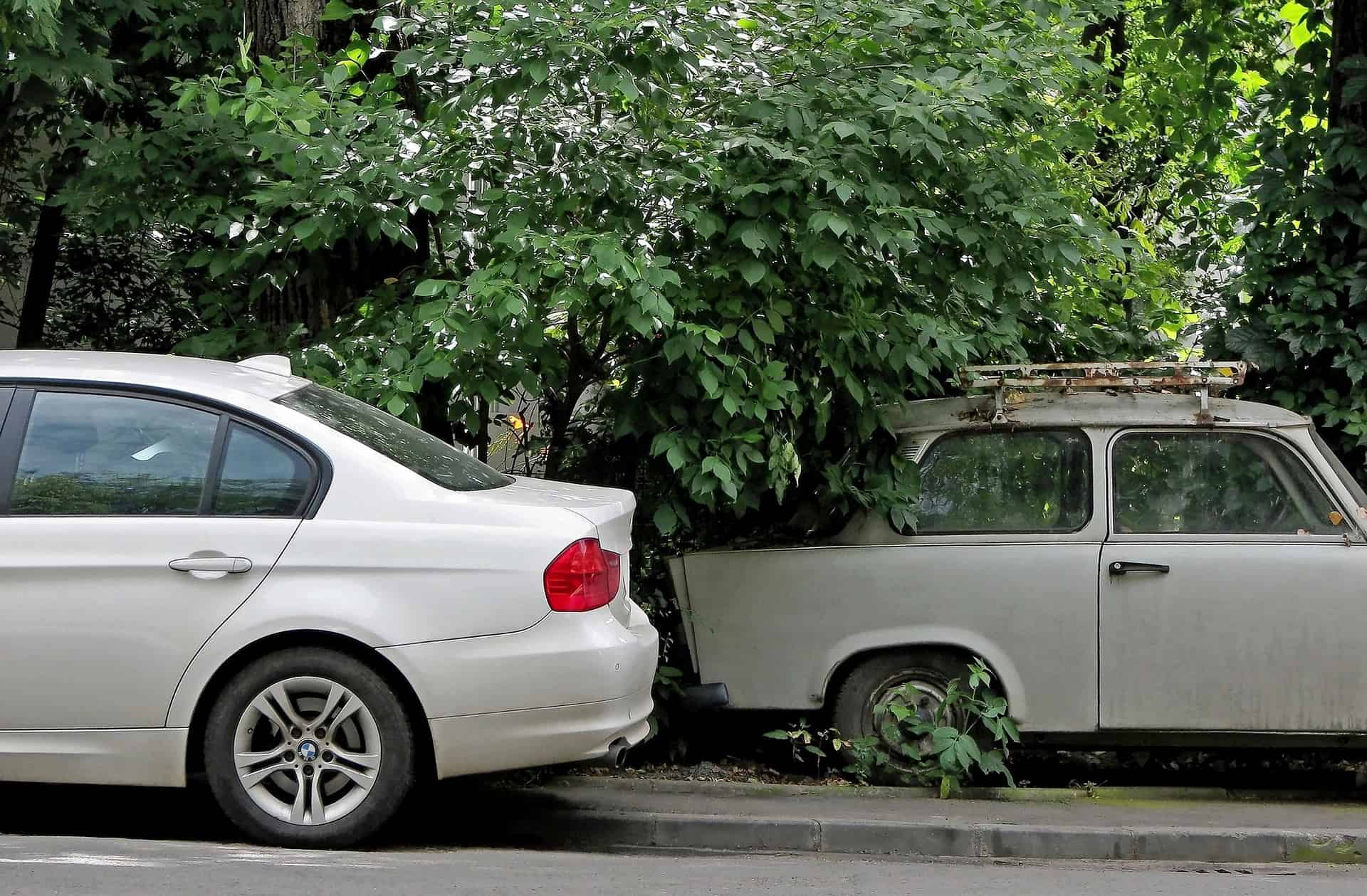 New BMW parked in front of an old BMW, comparing the styles and states.