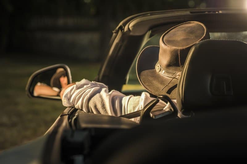 A man driving a high risk convertible car.