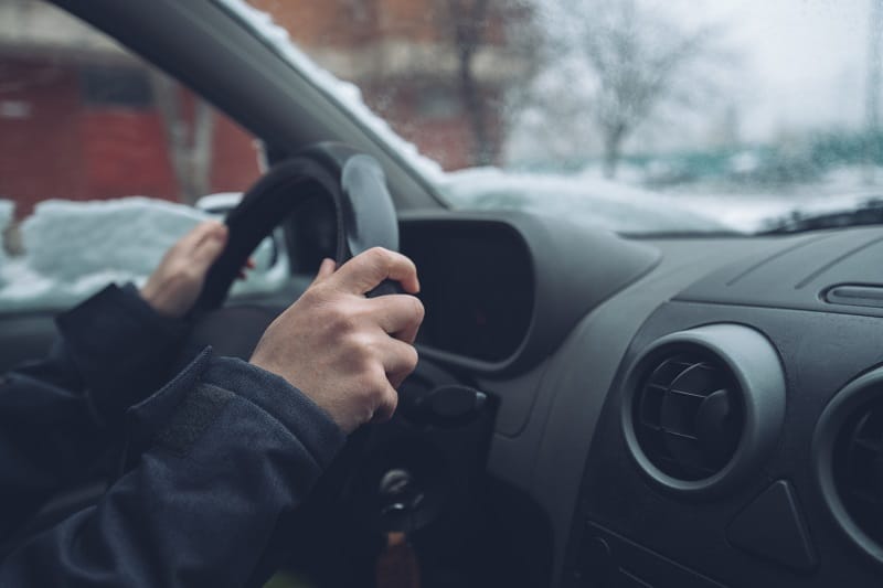 Waiting in car on winter day, female hands on steering wheel,