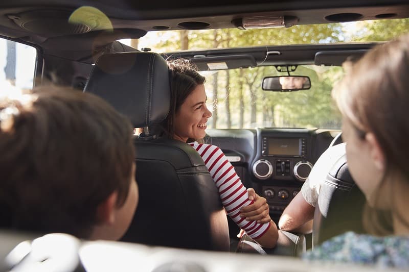 Family Driving In Open Top Car On Countryside Road Trip